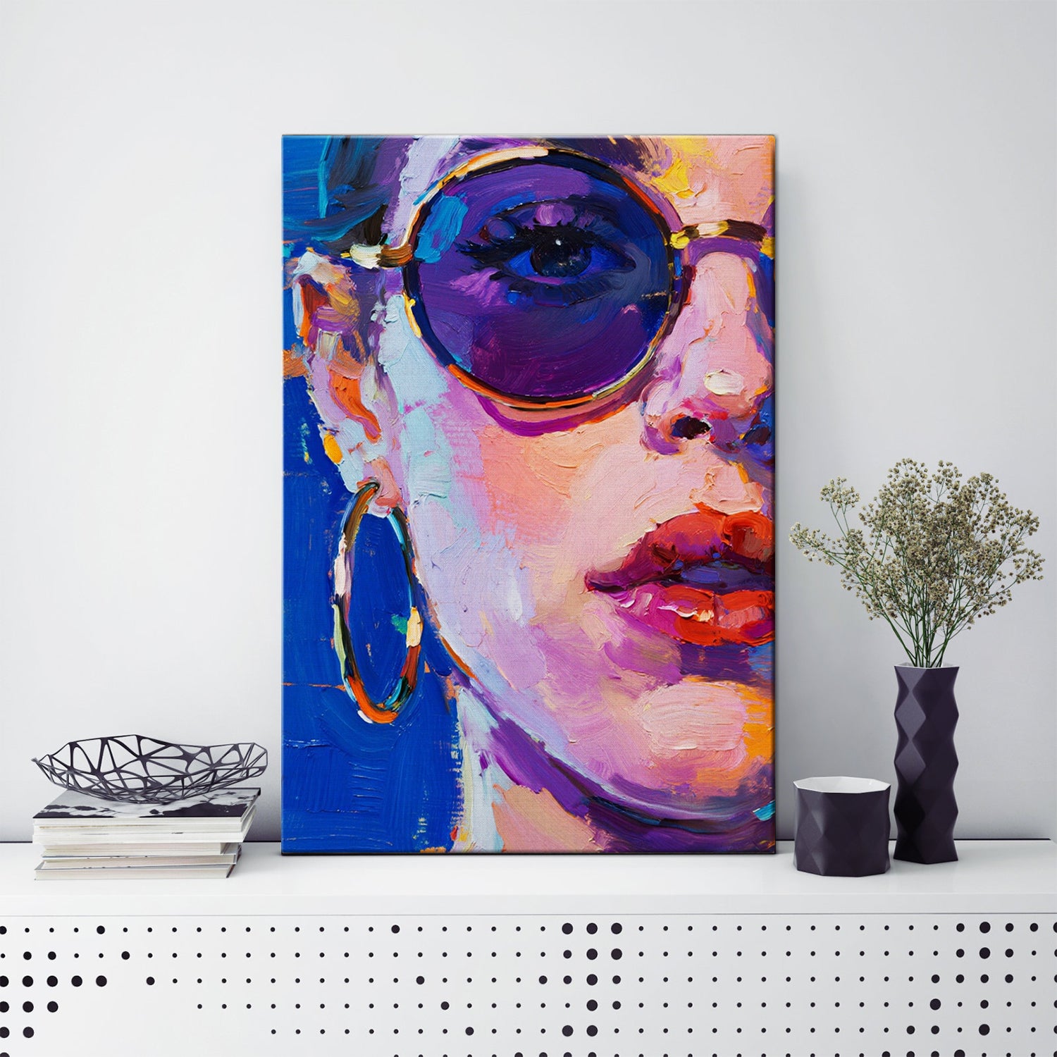 wall art painting on the table depicts woman wearing round sunglasses and large hoop earrings