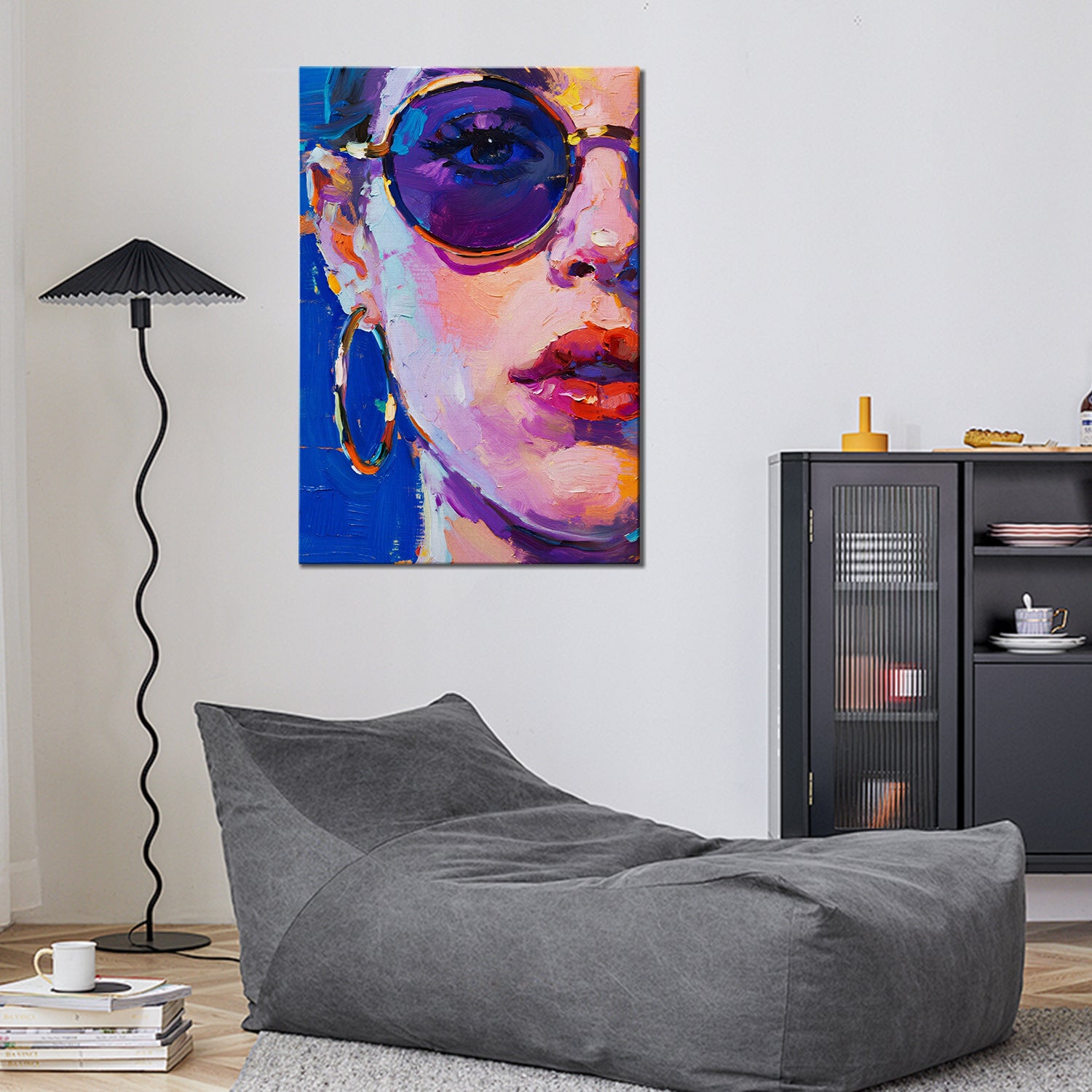 wall art painting in the living room depicts woman wearing round sunglasses and large hoop earrings
