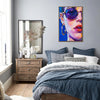 light oak color frame wall art painting depicts woman wearing round sunglasses and large hoop earrings