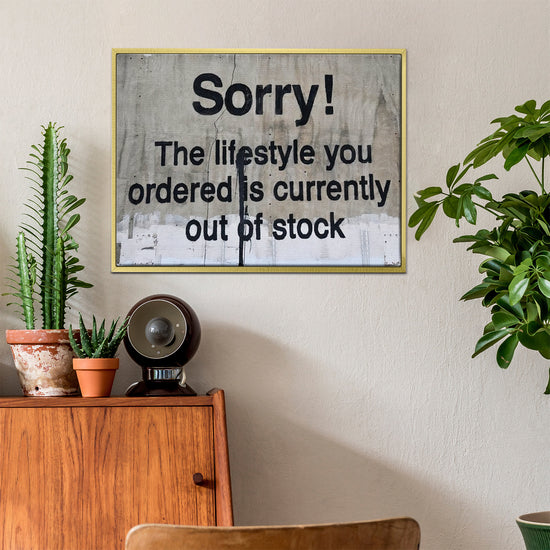 gold frame banksys statement canvas print hanging on the wall