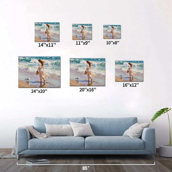 different size wall art painting depicts a woman in a flowing long dress walking on the beach, accompanied by seagulls.